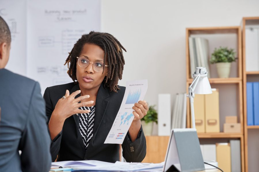 African-American business woman explaining results of her work to colleague